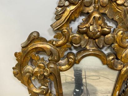 Gilded and openworked wood and stucco mirror...