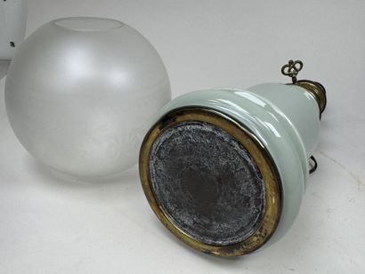 Lampe à pétrole en faïence sur fond vert...