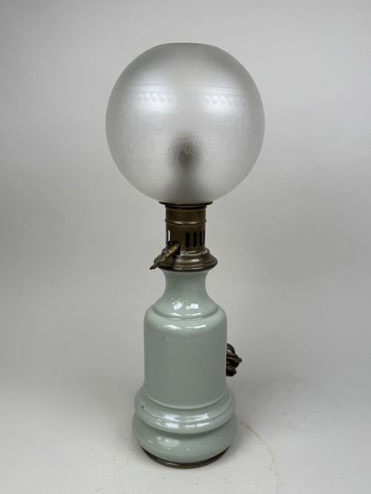 Lampe à pétrole en faïence sur fond vert...