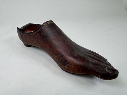 Sabot en bois sculpté en forme de pied.
L....