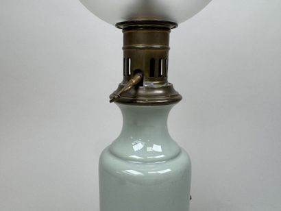 Lampe à pétrole en faïence sur fond vert...