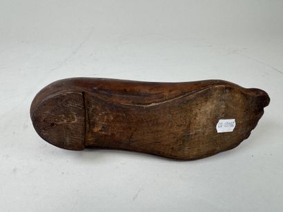 Sabot en bois sculpté en forme de pied.
L....