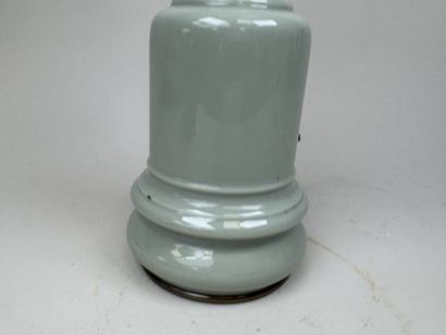 Lampe à pétrole en faïence sur fond vert...