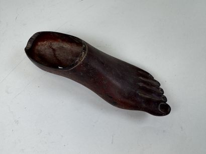 Sabot en bois sculpté en forme de pied.
L....