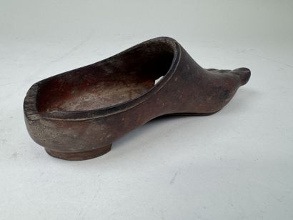 Sabot en bois sculpté en forme de pied.
L....