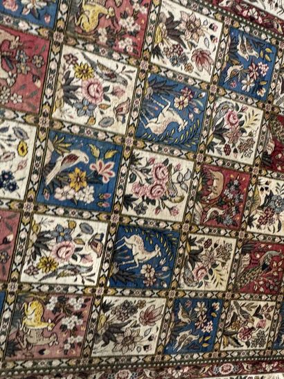 A large hand-knotted wool rug featuring stylized...