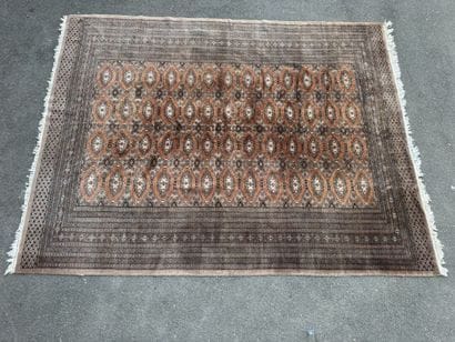 Large hand-knotted wool rug featuring stylized...