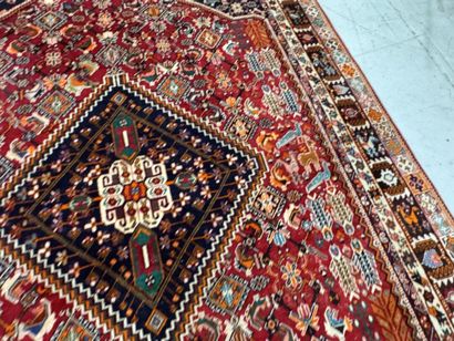 A large hand-knotted wool rug featuring stylized...