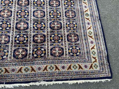 Hand-knotted wool rug with a blue background.
122...
