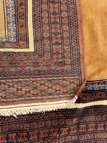 Small hand-knotted wool rug featuring a design...