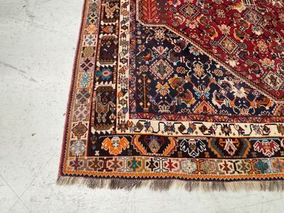 A large hand-knotted wool rug featuring stylized...
