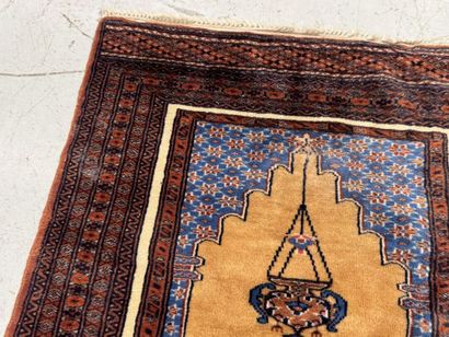 Small hand-knotted wool rug featuring a design...