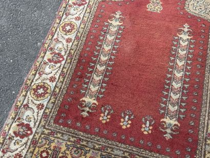 Hand-knotted wool rug featuring a red background...