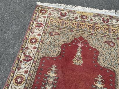 Hand-knotted wool rug featuring a red background...
