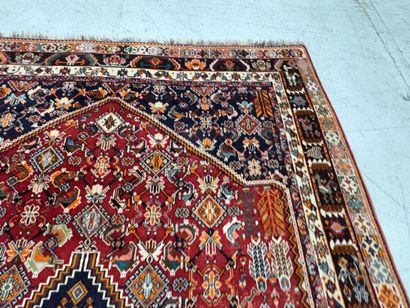 A large hand-knotted wool rug featuring stylized...