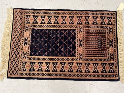 Small hand-knotted wool rug with stylized...
