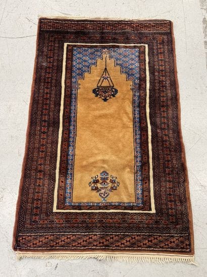Small hand-knotted wool rug featuring a design...