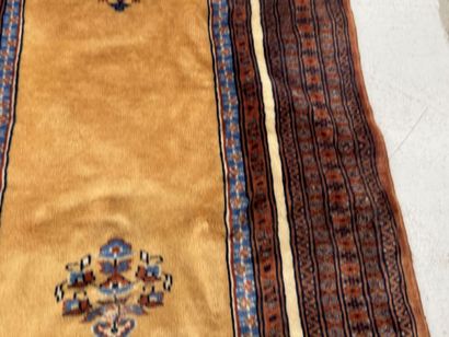 Small hand-knotted wool rug featuring a design...