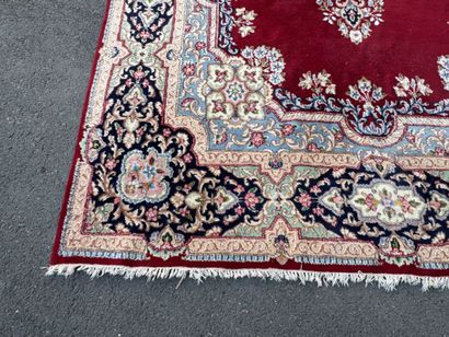 A large hand-knotted wool rug featuring a...