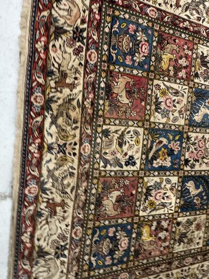A large hand-knotted wool rug featuring stylized...