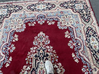 A large hand-knotted wool rug featuring a...