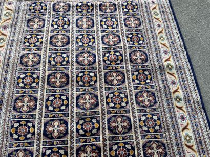 Hand-knotted wool rug with a blue background.
122...