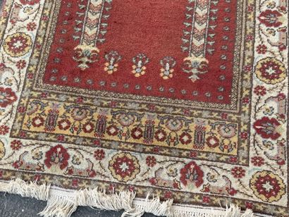 Hand-knotted wool rug featuring a red background...