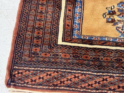 Small hand-knotted wool rug featuring a design...