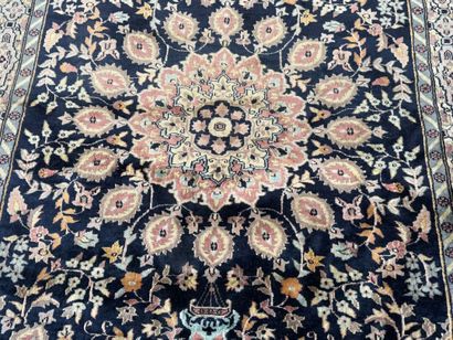 Hand-knotted wool rug featuring a foliage...