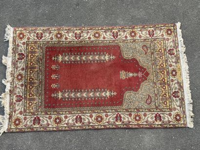 Hand-knotted wool rug featuring a red background...