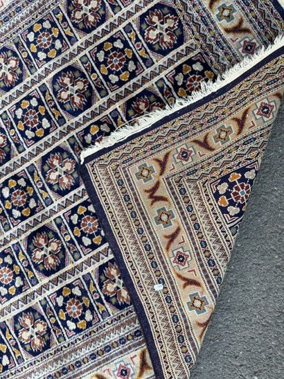Hand-knotted wool rug with a blue background.
122...