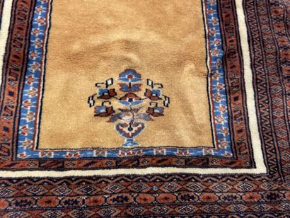 Small hand-knotted wool rug featuring a design...