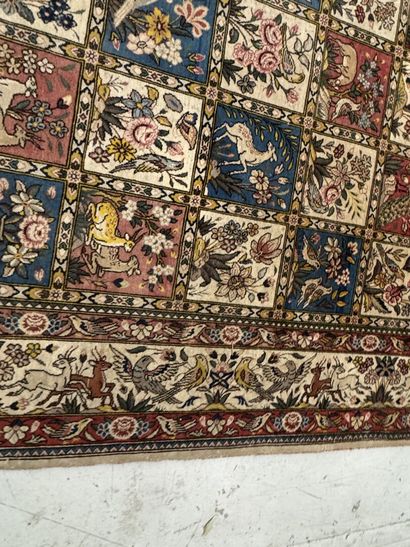 A large hand-knotted wool rug featuring stylized...