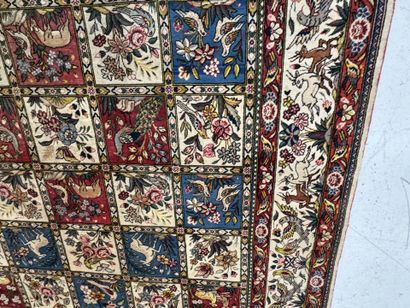 A large hand-knotted wool rug featuring stylized...