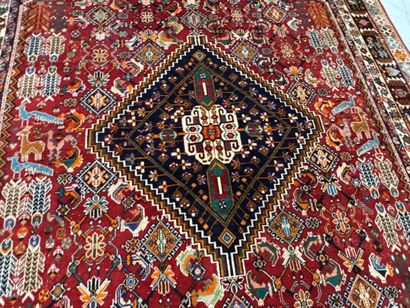A large hand-knotted wool rug featuring stylized...