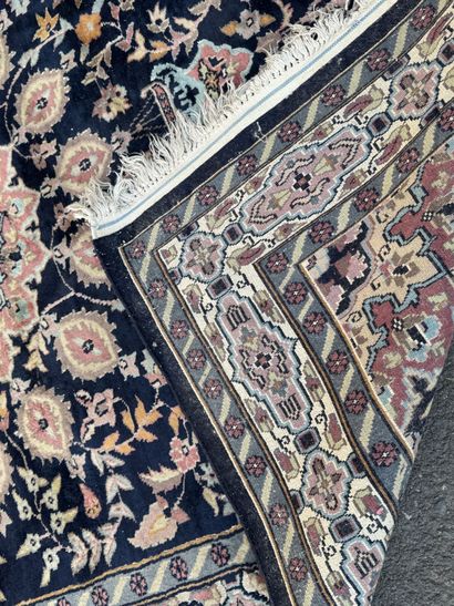 Hand-knotted wool rug featuring a foliage...