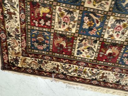 A large hand-knotted wool rug featuring stylized...