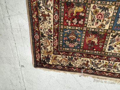 A large hand-knotted wool rug featuring stylized...
