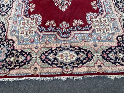 A large hand-knotted wool rug featuring a...