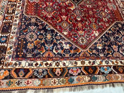 A large hand-knotted wool rug featuring stylized...