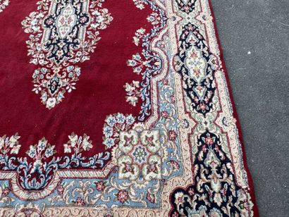 A large hand-knotted wool rug featuring a...