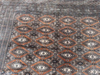 Large hand-knotted wool rug featuring stylized...