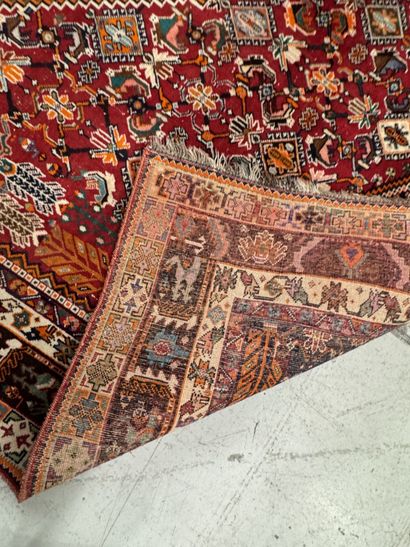 A large hand-knotted wool rug featuring stylized...