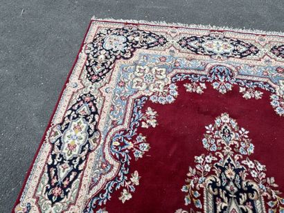 A large hand-knotted wool rug featuring a...