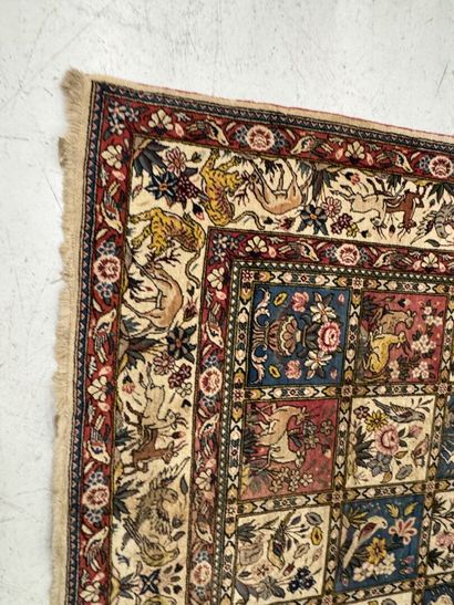 A large hand-knotted wool rug featuring stylized...