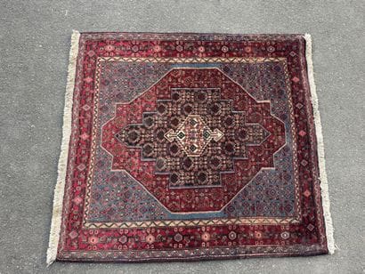 Hand-knotted wool rug featuring stylized...