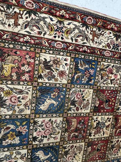 A large hand-knotted wool rug featuring stylized...