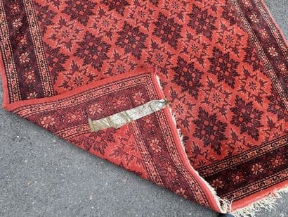 Hand-knotted wool rug with an orange background.
215...