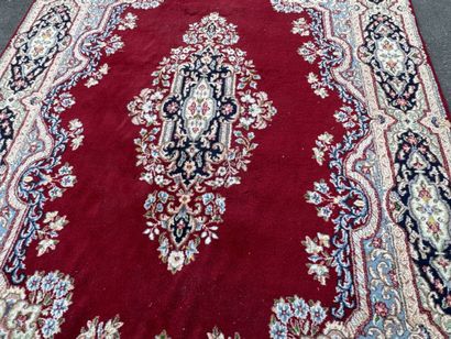 A large hand-knotted wool rug featuring a...
