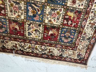 A large hand-knotted wool rug featuring stylized...